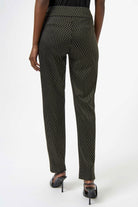 Black patterned pants worn by a person on a white background
