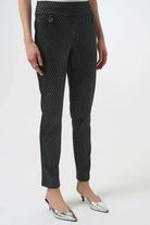 Black patterned pants worn by a person on a white background