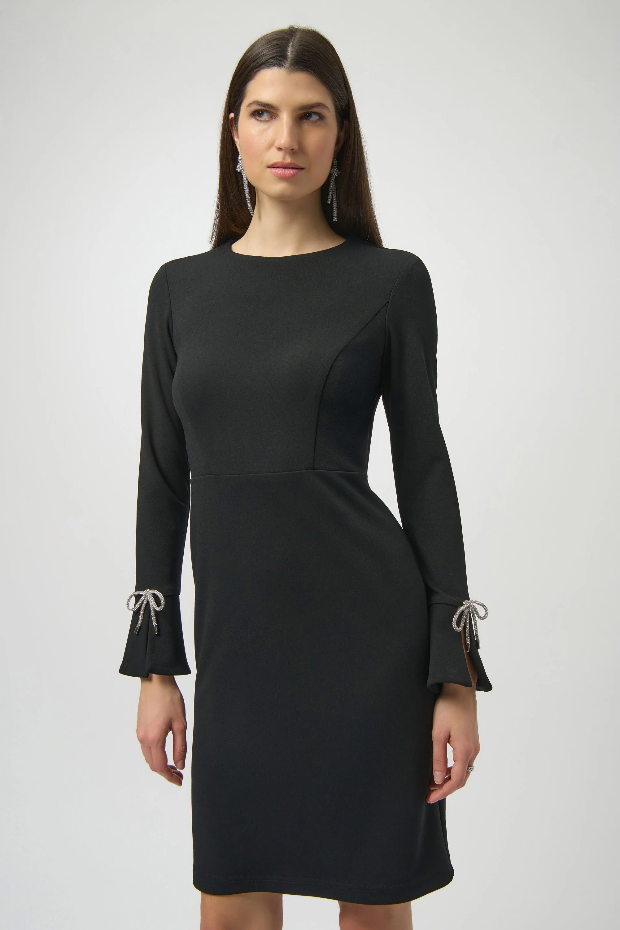 Black dress with long sleeves and decorative elements on a white background