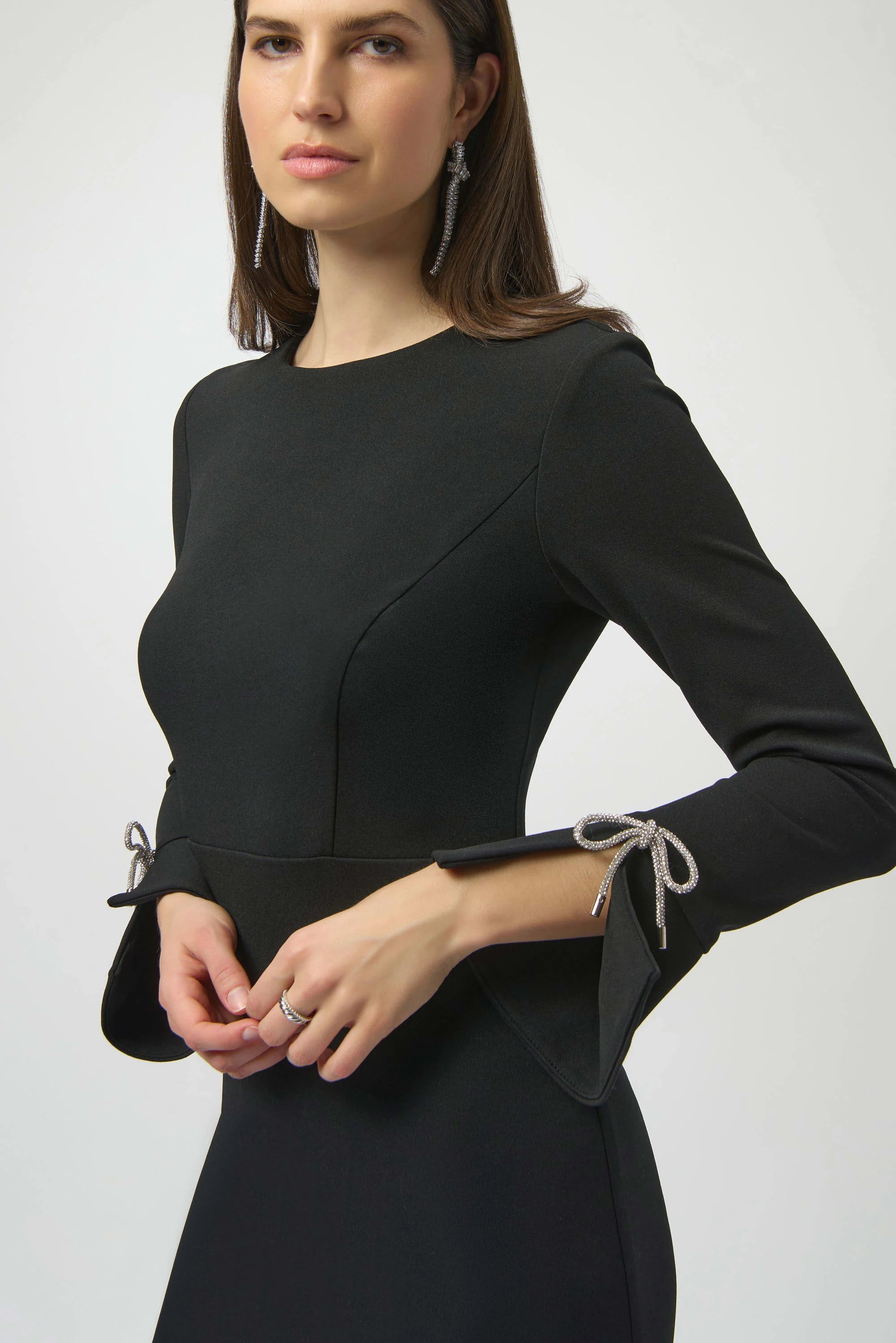 Woman wearing a black dress with long sleeves on a white background