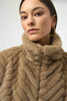 Woman wearing a beige fur coat with a white background