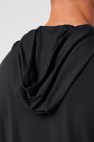 Close-up of a black garment with a hood on a plain background