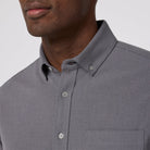 Gray button-up shirt worn by a person on a plain background