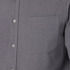 Close-up of a gray shirt with a pocket and buttons.