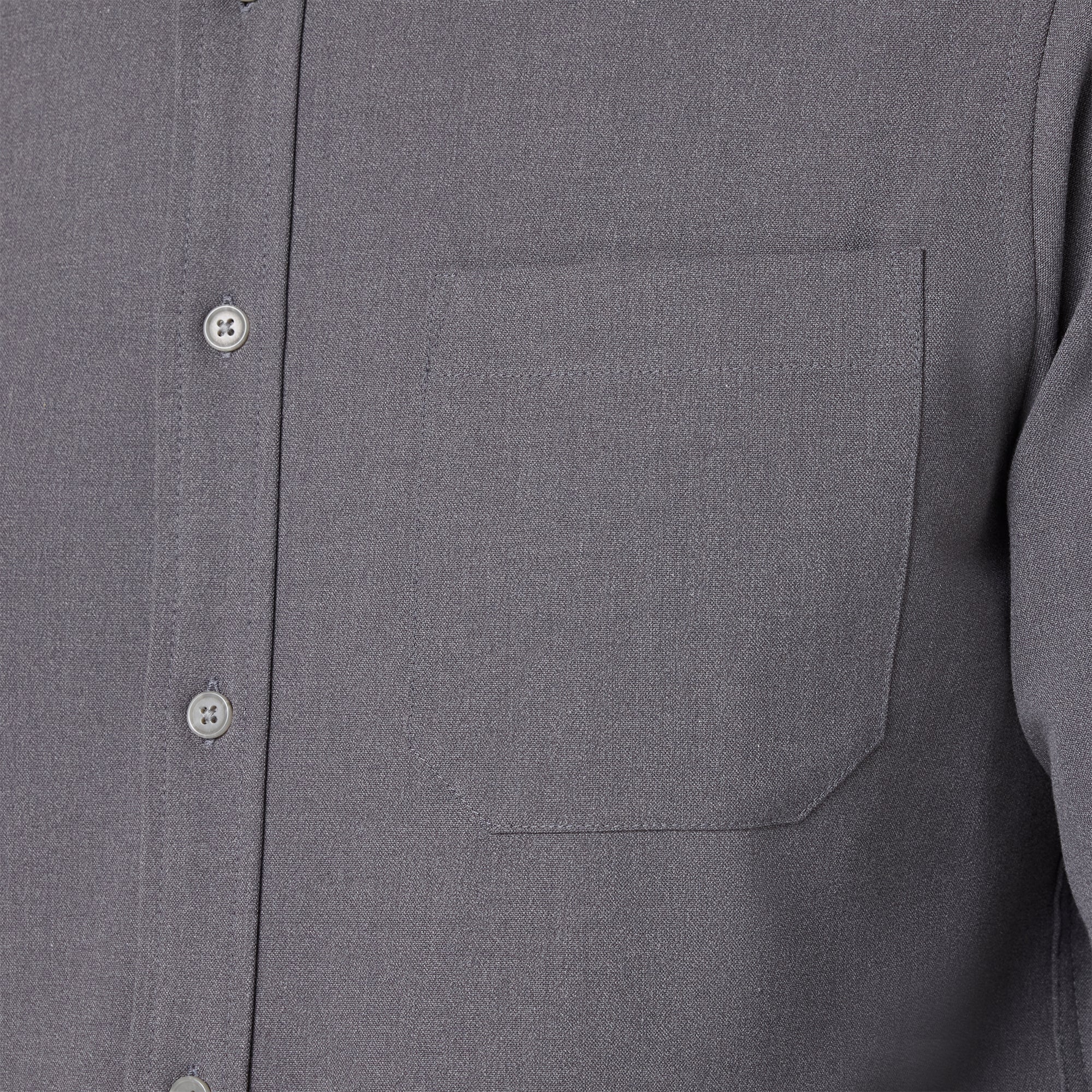 Close-up of a gray shirt with a pocket and buttons.