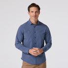 Man wearing a blue checkered shirt on a light gray background