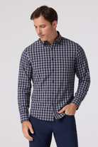 Man wearing a blue and white checkered shirt against a light gray background