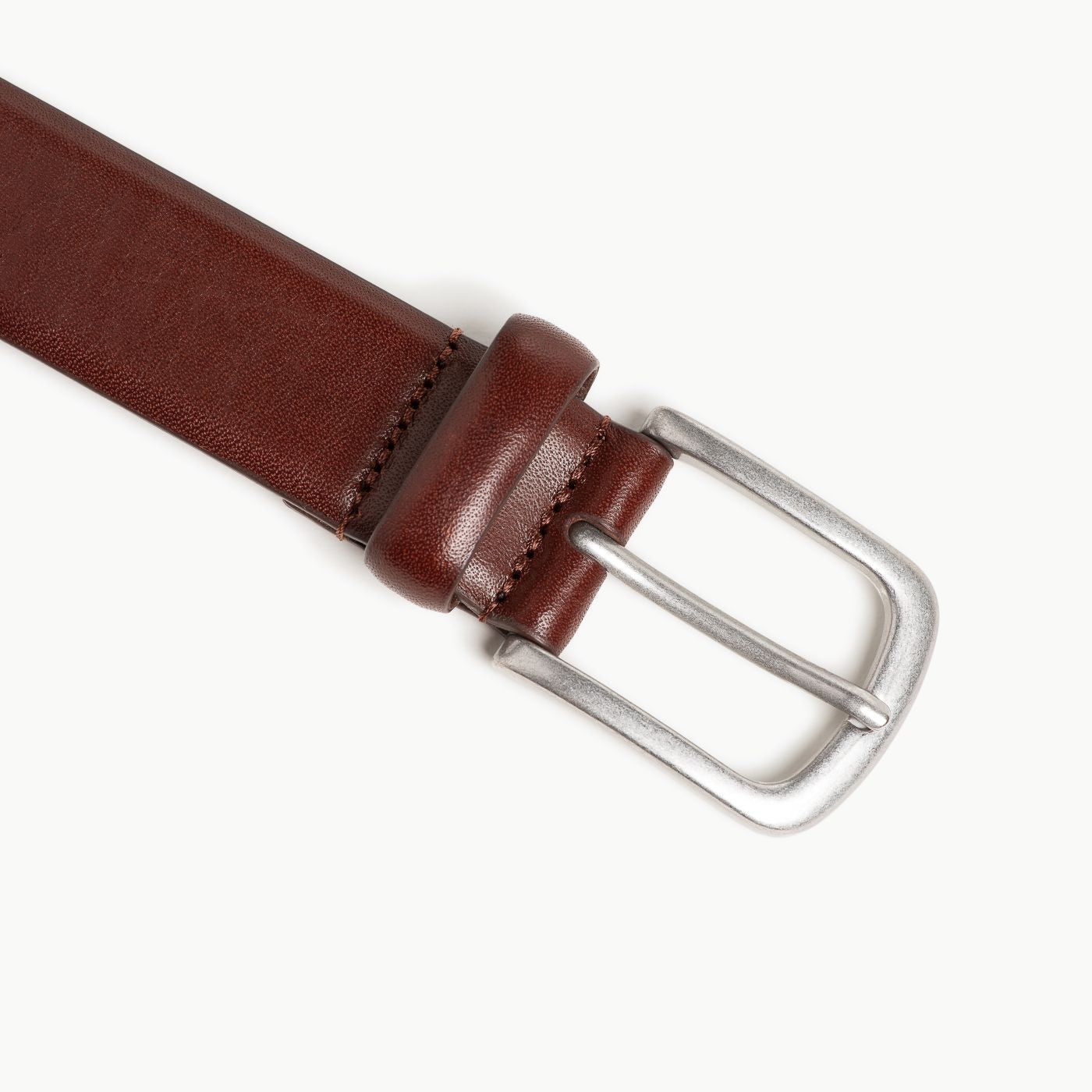 Brown leather belt with a silver buckle on a white background