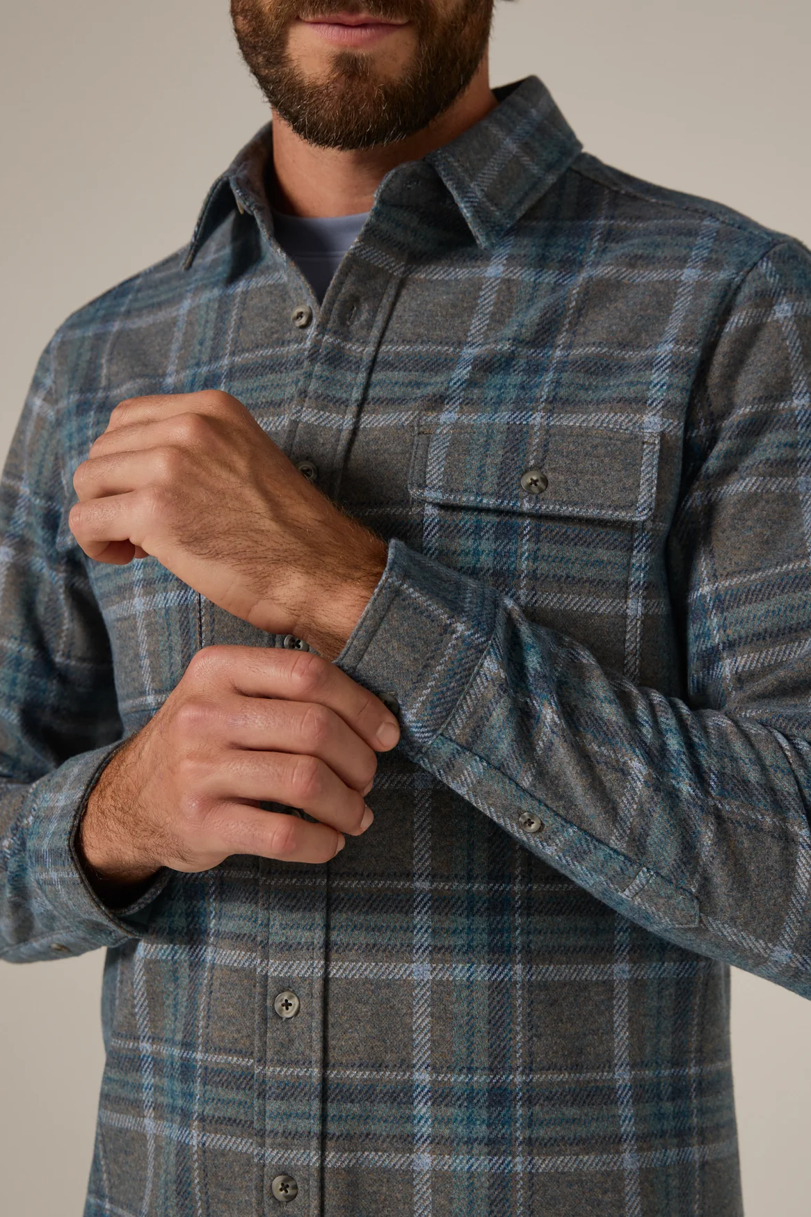 Man wearing a plaid shirt with a neutral background