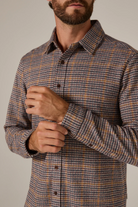 Man wearing a plaid shirt with a neutral background