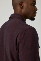 Man wearing a dark brown textured shirt against a plain background