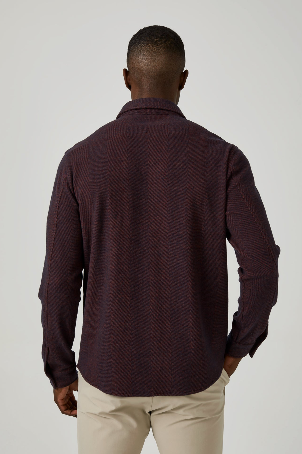 Man wearing a dark brown long-sleeve shirt against a white background