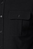 Close-up of a black shirt with a pocket and button details.