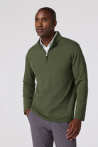 Man wearing a green pullover with a white background