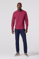 Man wearing a red shirt and blue pants on a white background