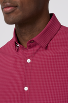 Close-up of a person wearing a red checkered shirt with a white background