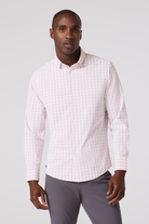 Man wearing a white checkered shirt and gray pants on a light gray background