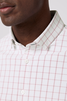 Close-up of a man wearing a white shirt with red plaid pattern on a light gray background