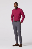 Man wearing a red shirt and gray pants on a white background