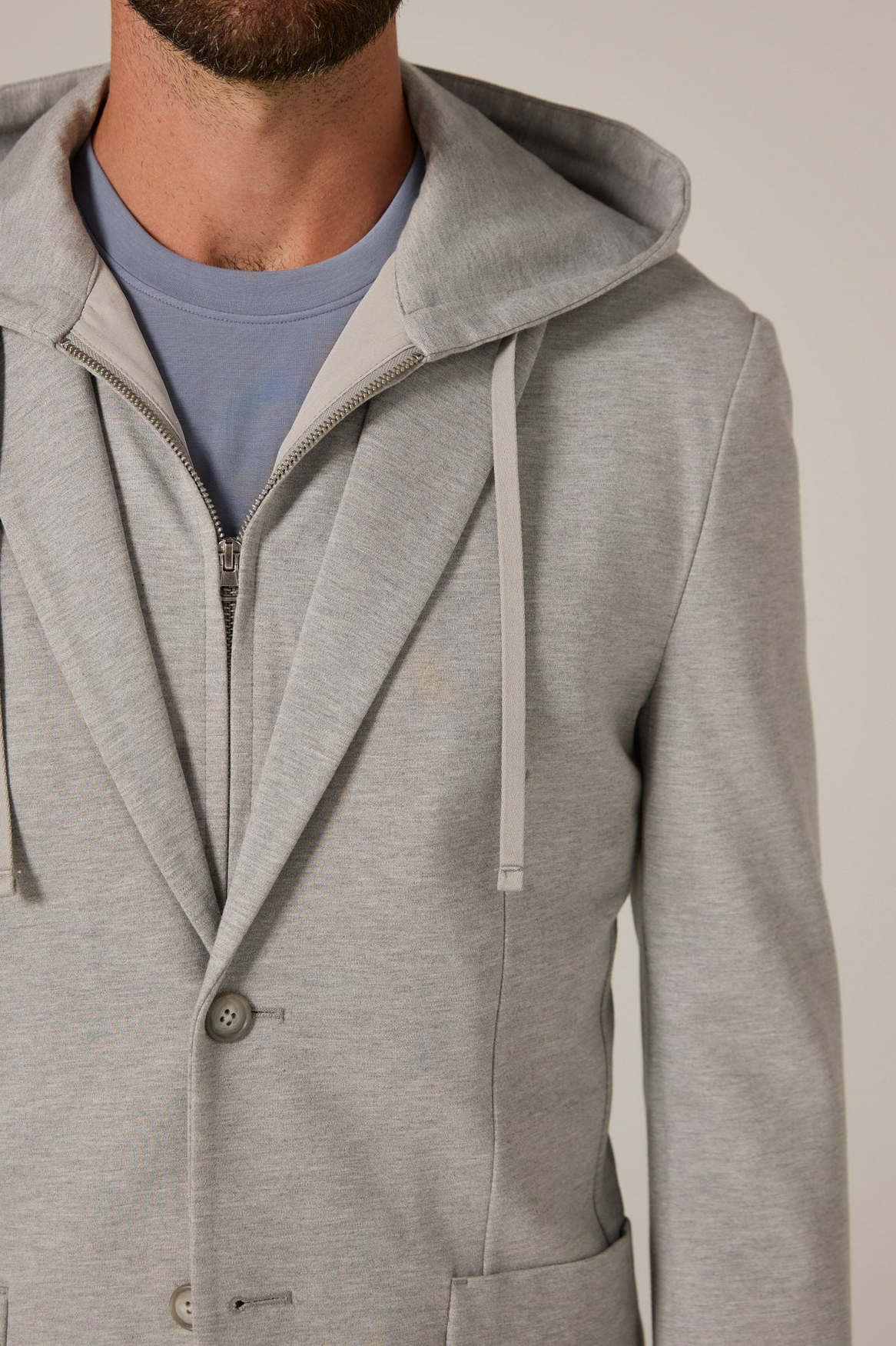 Gray hooded jacket worn by a person on a neutral background