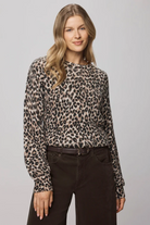 Woman wearing a leopard print long-sleeve top against a gray background