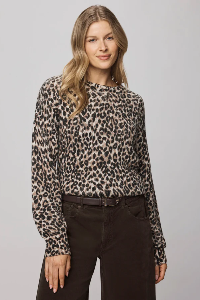 Woman wearing a leopard print long-sleeve top against a gray background