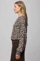Woman wearing a leopard print top against a plain background
