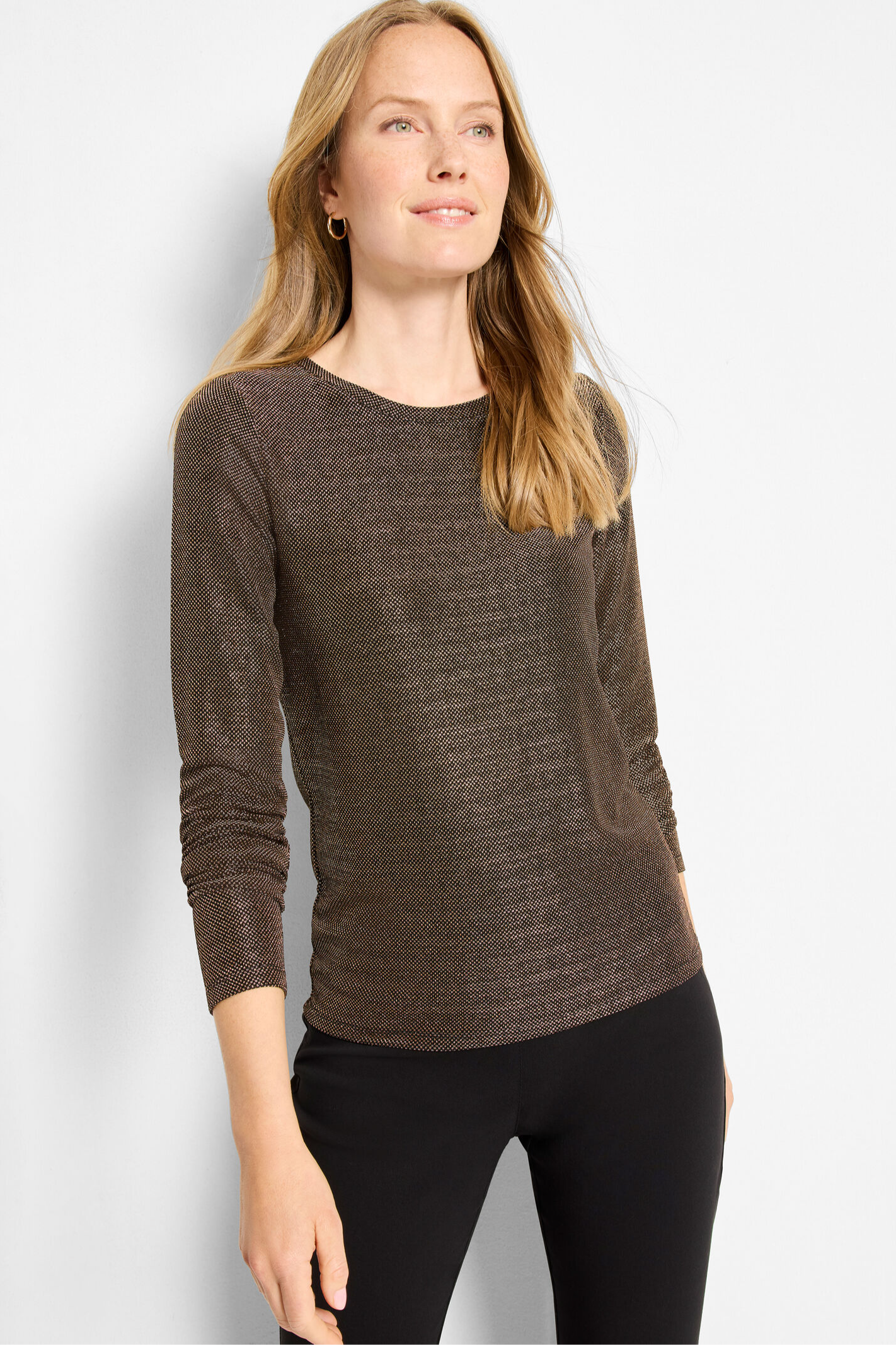 Woman wearing a brown sweater against a white background