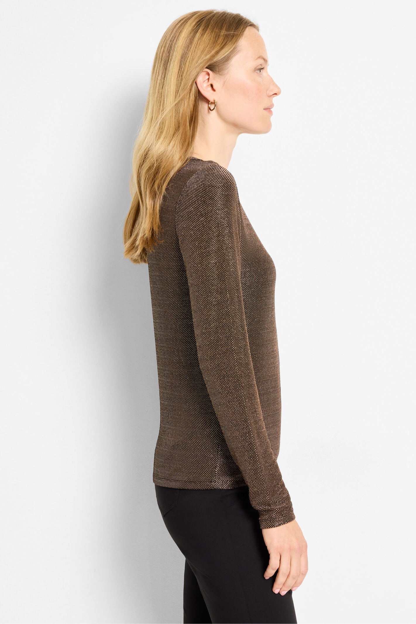 Woman wearing a brown long-sleeve top against a white background