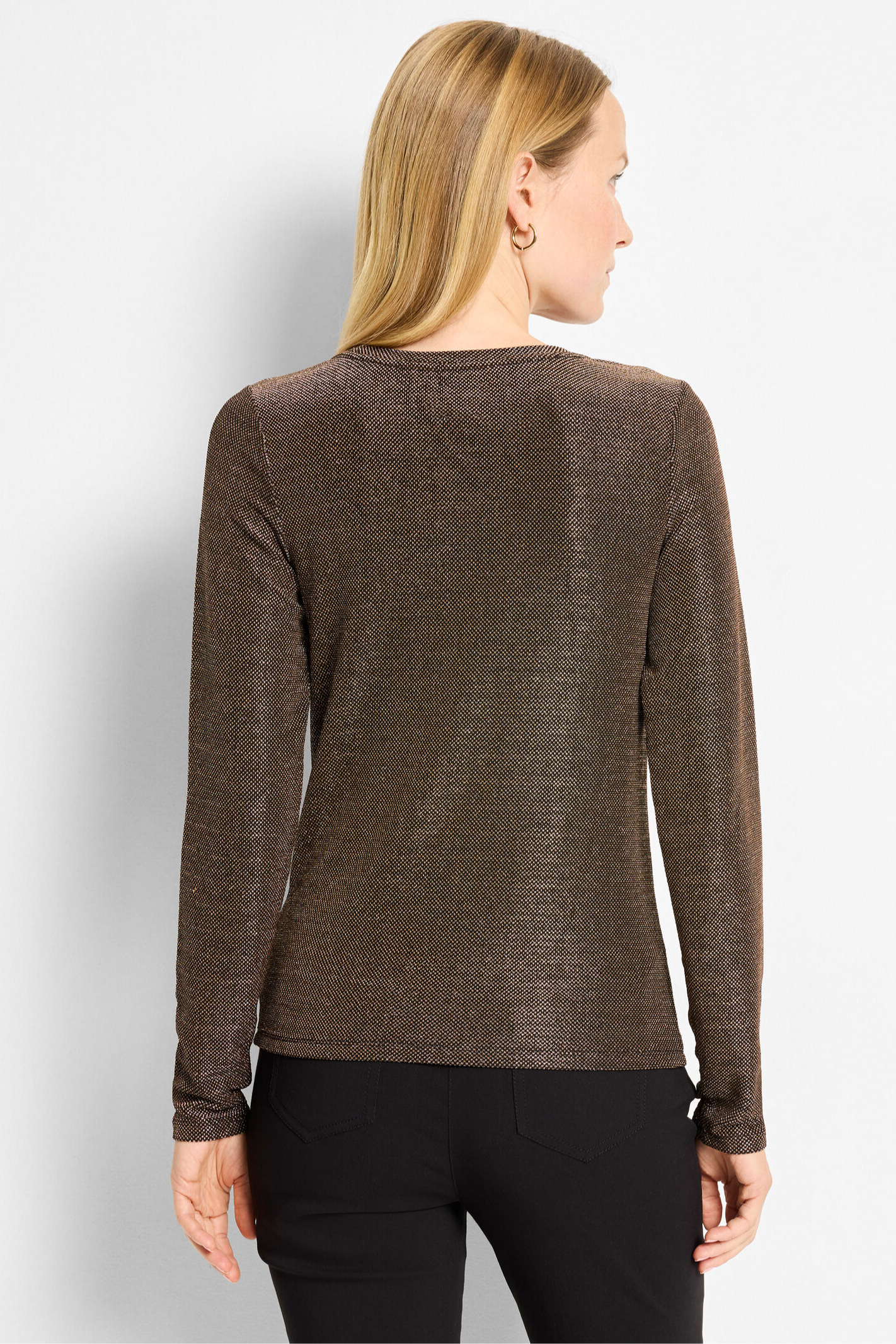 Woman wearing a brown sweater against a light gray background