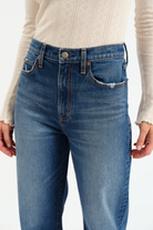 Blue jeans worn by a person on a white background