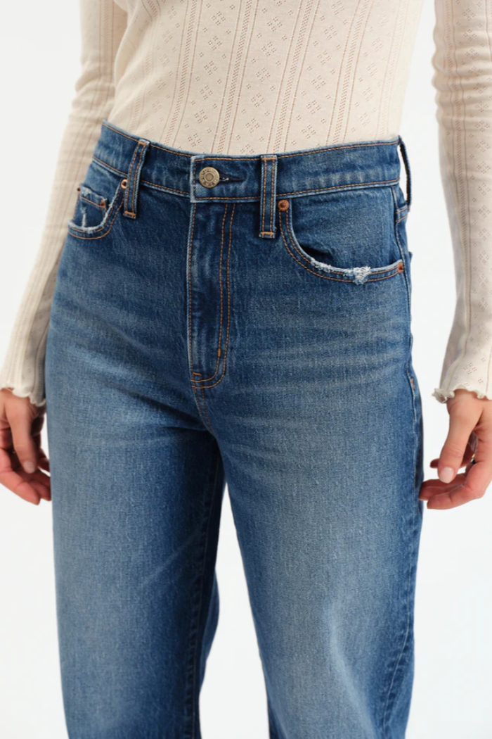 Blue jeans worn by a person on a white background