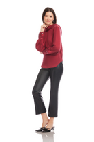 Woman wearing a red blouse and black pants on a white background
