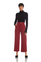 Woman wearing a black turtleneck and red pants on a white background