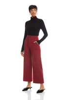 Woman wearing a black turtleneck and red pants on a white background