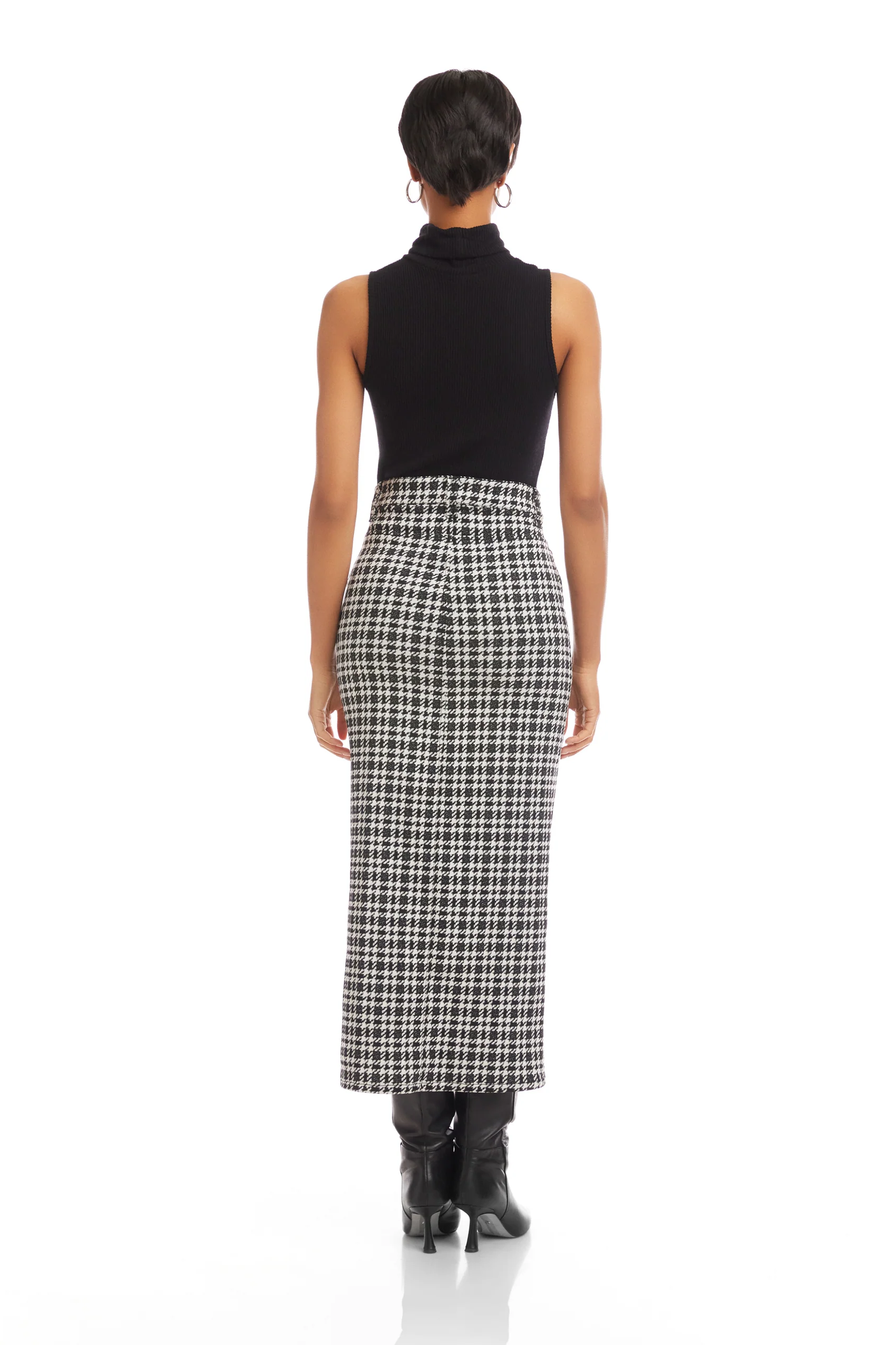 Person wearing a black sleeveless top and plaid skirt on a white background