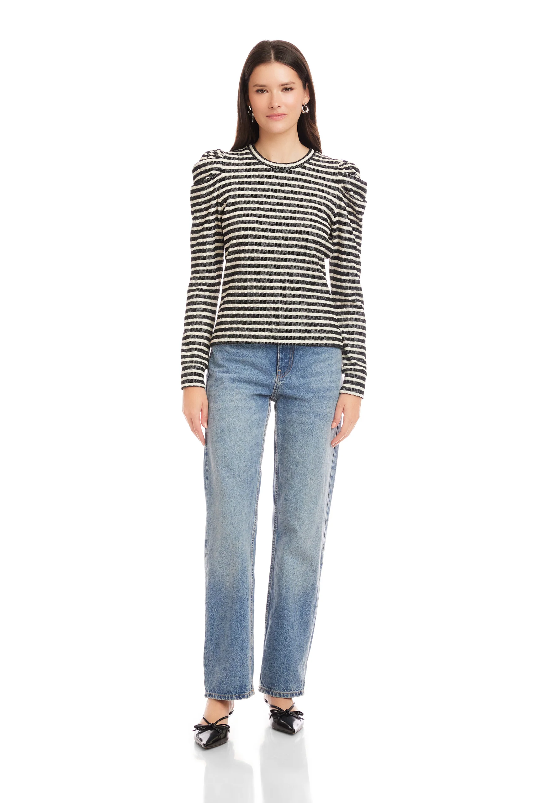Woman wearing a black and white striped long-sleeve shirt and blue jeans on a white background