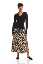 Woman wearing a black long-sleeve top and zebra print skirt on a white background