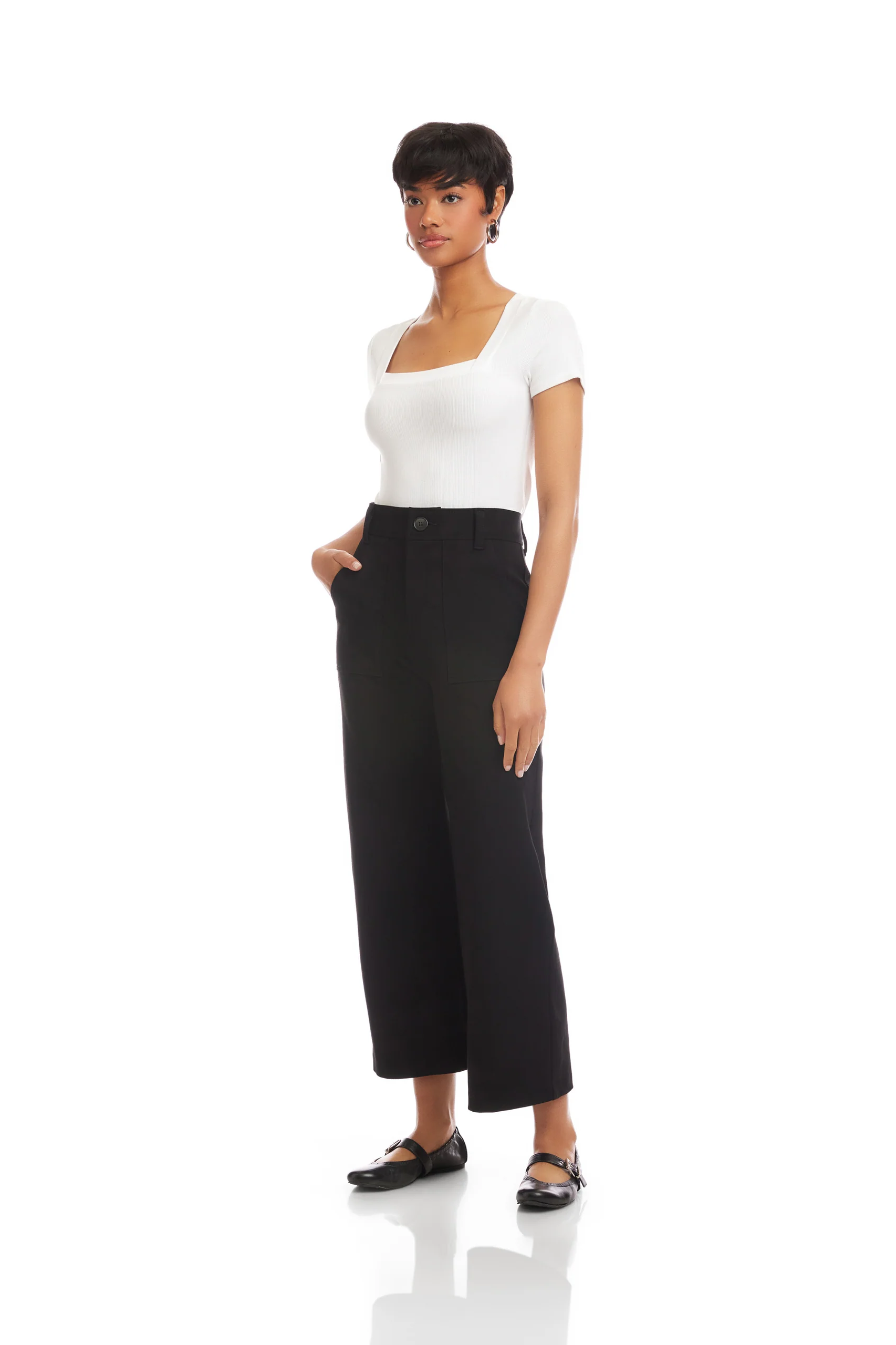 Woman wearing a white top and black wide-leg pants on a white background