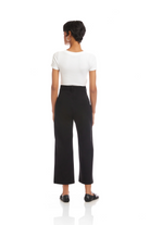 Person wearing a white top and black pants on a white background