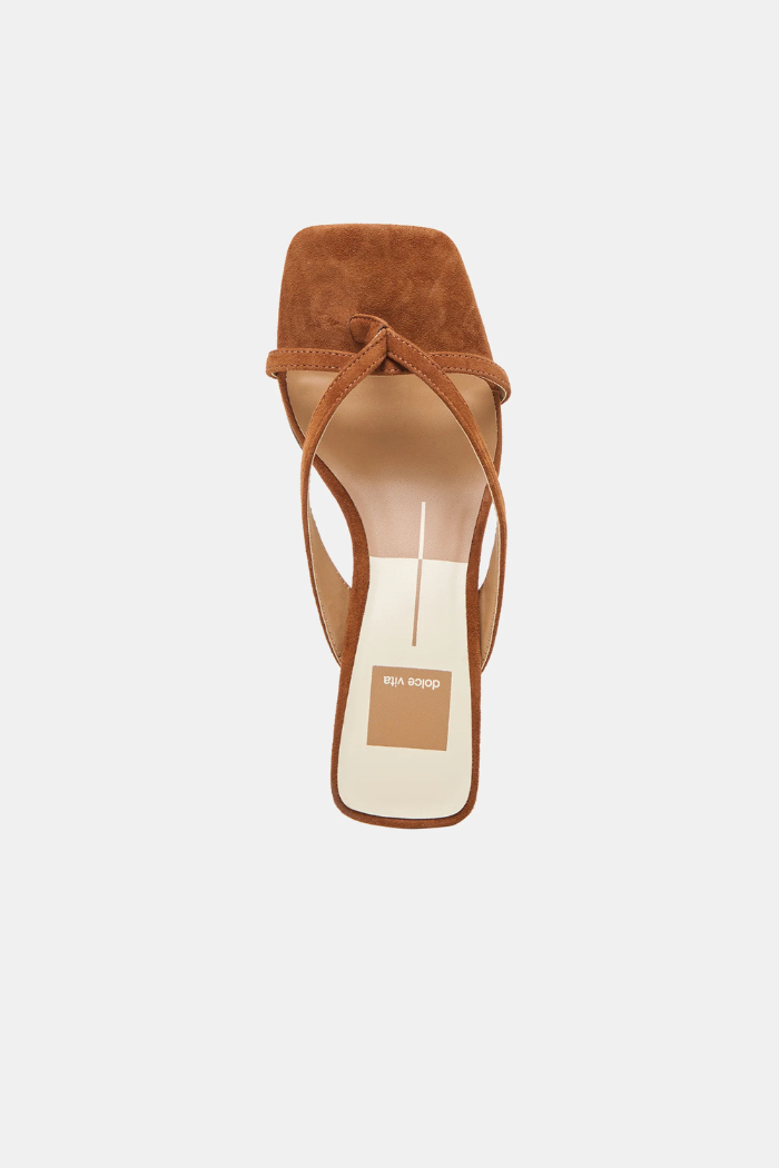Brown sandal with a white sole on a light beige background