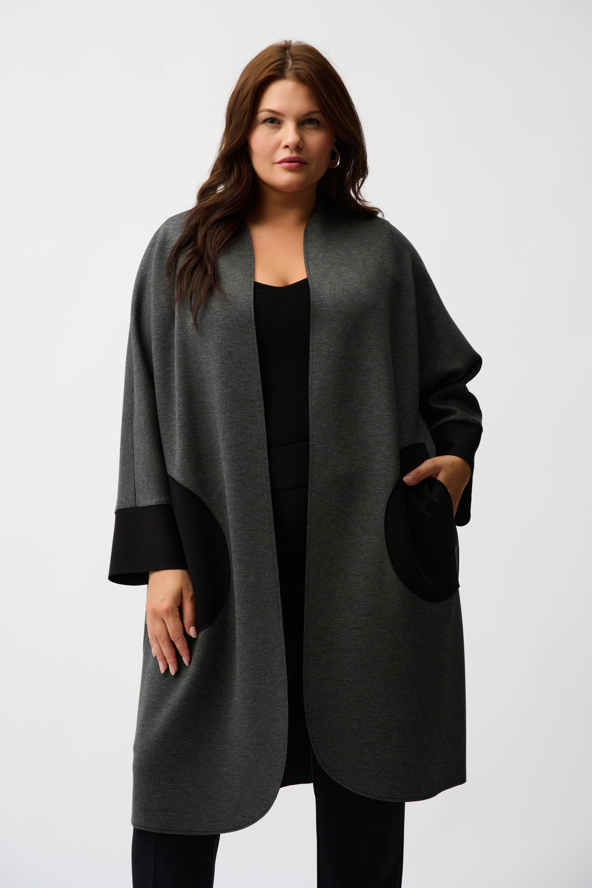 Woman wearing a gray and black coat on a white background