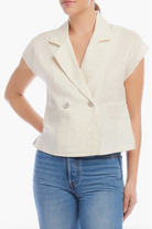Woman wearing a white blazer over a blue top on a white background