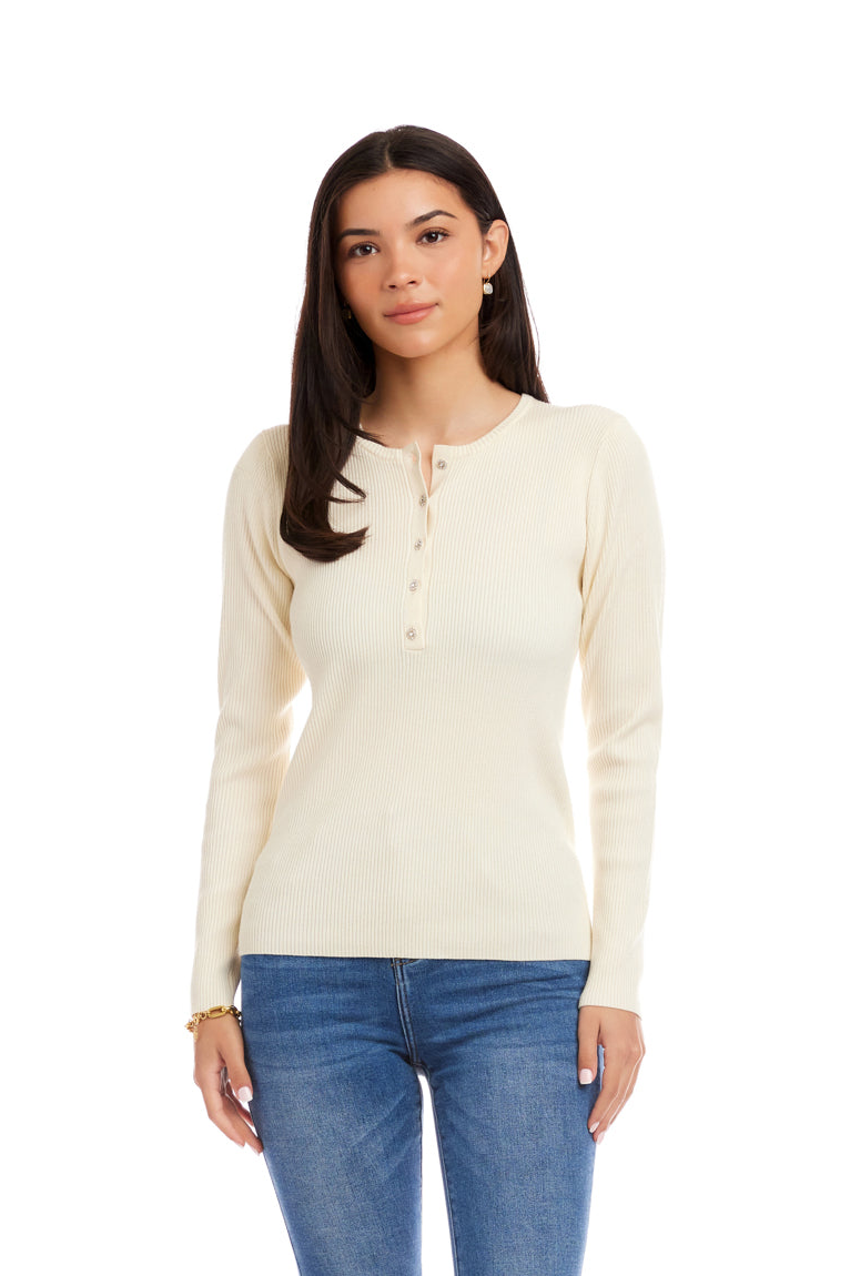 Woman wearing a cream long-sleeve henley shirt and blue jeans on a white background