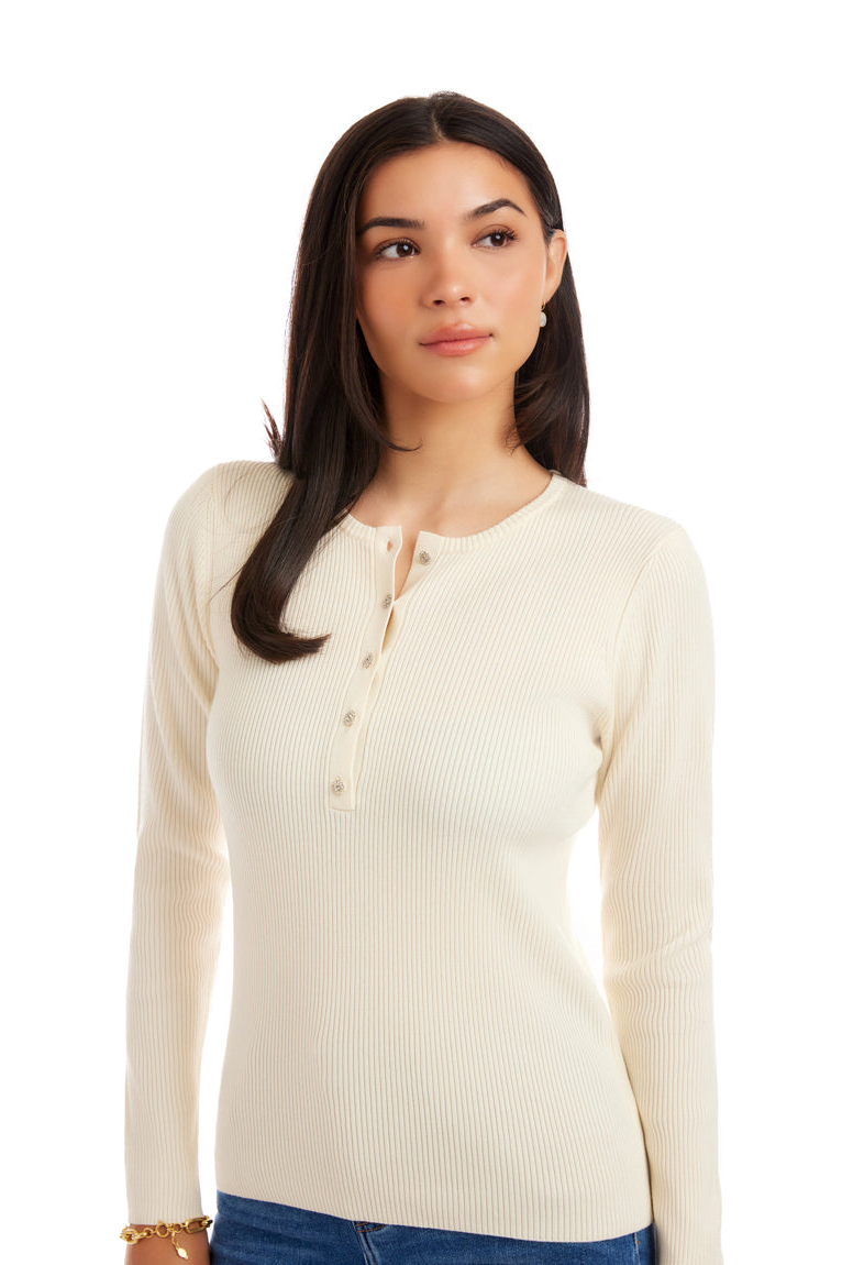 Woman wearing a cream-colored ribbed sweater on a white background