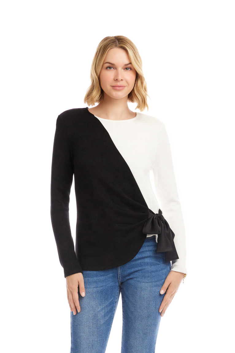 Woman wearing a black and white sweater with blue jeans on a white background