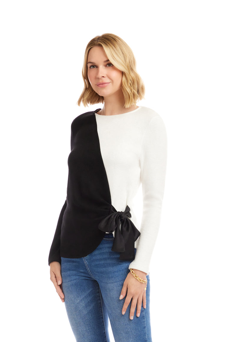 Woman wearing a black and white top with a bow detail on a white background