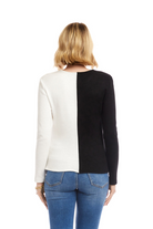 Person wearing a black and white long-sleeve top with blue jeans on a white background