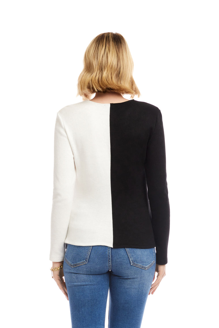 Person wearing a black and white long-sleeve top with blue jeans on a white background