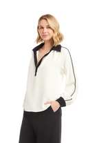 Woman wearing a white blouse with black accents on a white background